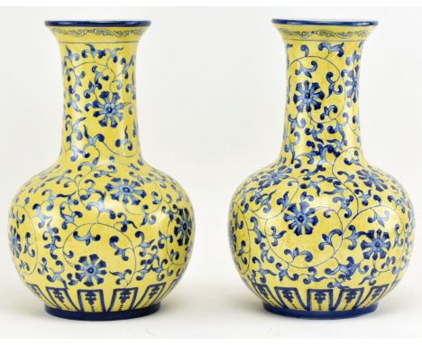 A pair of Chinese Qianlong marked ceramic yellow blue and white glazed vases. Each vase having a flared rim over long cylindr