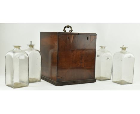 A 19th century George III mahogany campaign decanter box. The box of square upright form with brass handle between two slidin