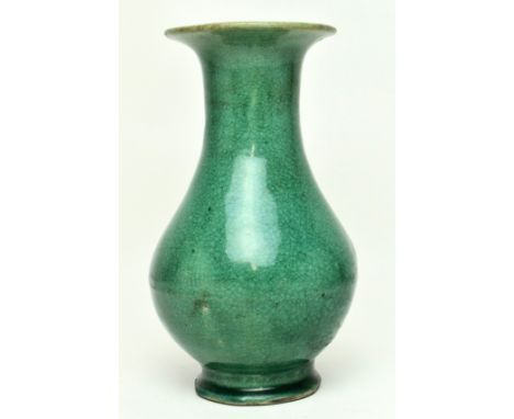 A Chinese late Qing Dynasty early 19th century green glazed ceramic footed vase. The vase of baluster form with lipped flared