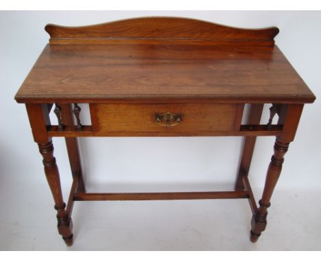 A late Victorian James Shoolbred & Co walnut writing table, the rectangular top with shaped gallery back above a balustrade t