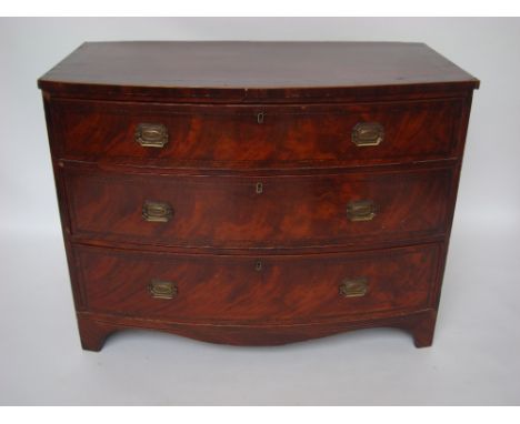 An early 19th Century mahogany bowfront chest of drawers, the top crossbanded and strung over three graduated long drawers, r