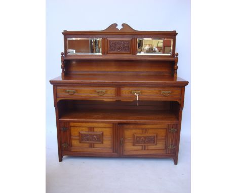 A late Victorian aesthetic movement mahogany sideboard, the raised back inset with bevelled mirror above a single shelf raise