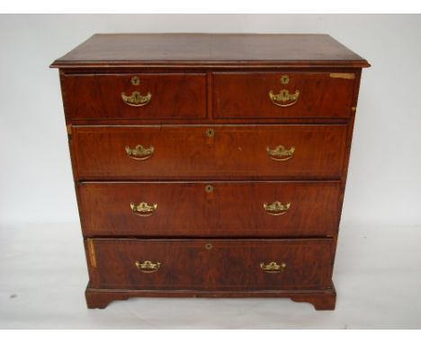 An 18th Century walnut chest of drawers, the quarter veneered and featherbanded top with moulded edge above two short and thr