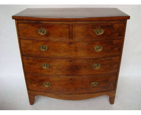A 19th Century mahogany bowfront chest of drawers with two short and three graduated long cockbeaded drawers with later oval 