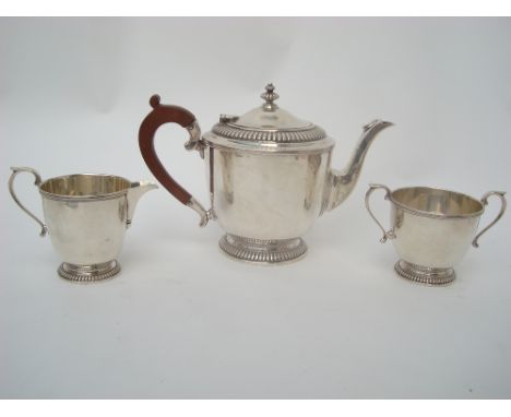 A George V silver three piece silver tea service, Sheffield, 1933 by Mappin & Webb, each piece of circular form on foot with 