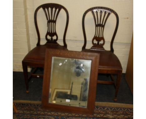 A Victorian oak wall mirror with rectangular bevelled plate, together with a pair of Edwardian mahogany dining chairs, each h