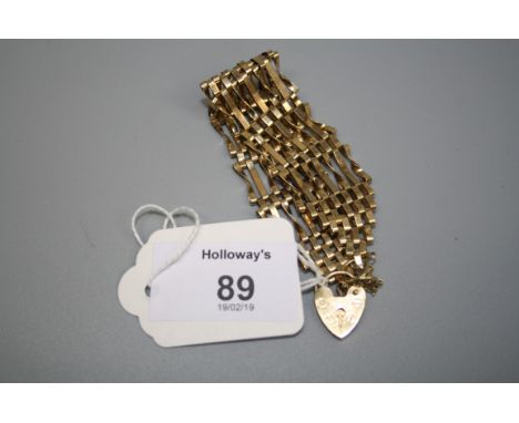 A 9ct gold wide gate link bracelet with padlock clasp