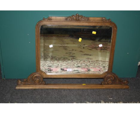 A 1920s carved oak overmantel mirror with scroll supports, 102cm wide
