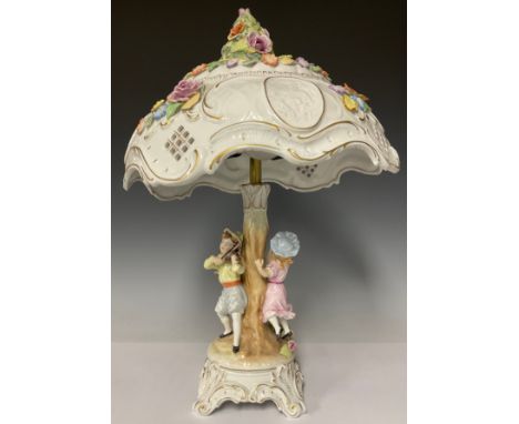 A German Schierholz porcelain table lamp, the domed pierced shade applied with flowers in relief, four oval cameo lithophane 