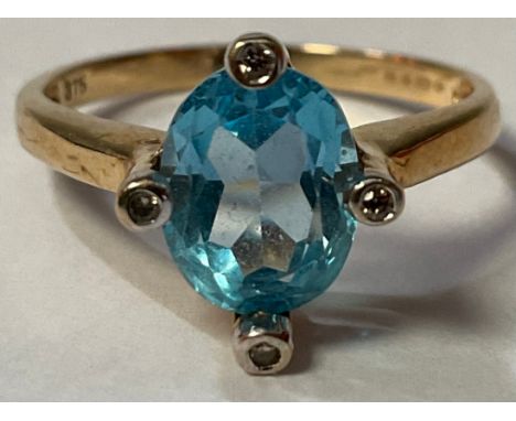 A 9ct gold ring, set with a central faceted topaz, surrounded by four illusion set diamond chips, size Q, 3g, boxed 