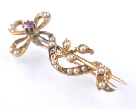 An 18ct gold ruby and seed pearl brooch - stick pin. The round cut ruby in claw setting with bow of seed pearls. Pin verso. U