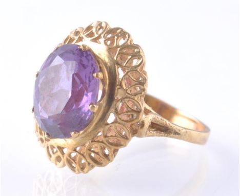 A mid century 14ct gold and synthetic colour change sapphire dress ring. The ring having a prong set oval mixed cut synthetic