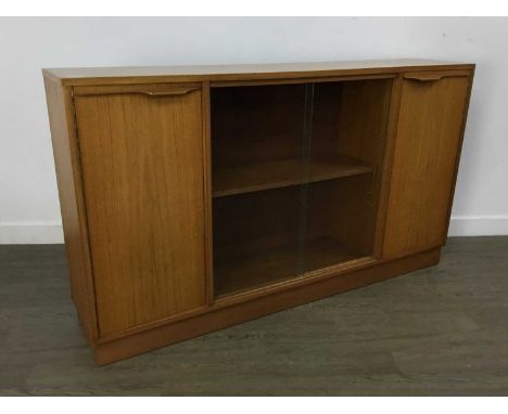 MCINTOSH OF KIRKCALDY, TEAK BOOKCASE 1970-79 with twin glass doors enclosing single shelf flanked by twin cupboard doors77cm 