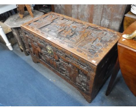AN INDONESIAN CAMPHOR WOOD TRUNK with all-over carved decoration 40" wide