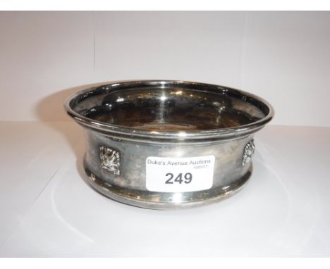 A GEORGE V BIRMINGHAM SILVER DECANTER COASTER with moulded silver rosette decoration