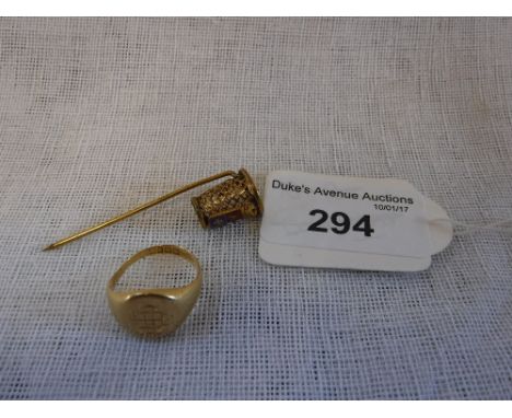 AN 18CT YELLOW GOLD OVAL HEAD SIGNET RING and a gilt metal basket stick-pin with enamelled crest (2)