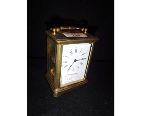 A BRASS CASED CARRIAGE CLOCK with white enamel dial
