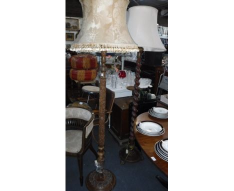 A STANDARD LAMP, with tapering spiral column on paw feet and a carved standard lamp
