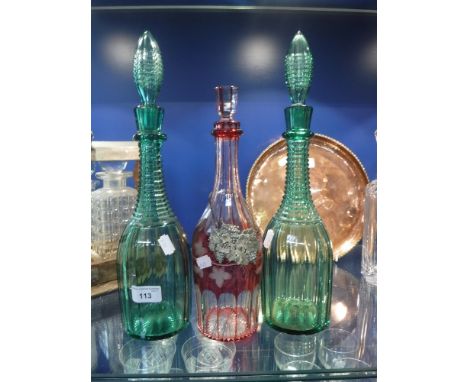 A PAIR OF GREEN TALL NECKED DECANTERS AND STOPPERS and a similar overlaid decanter