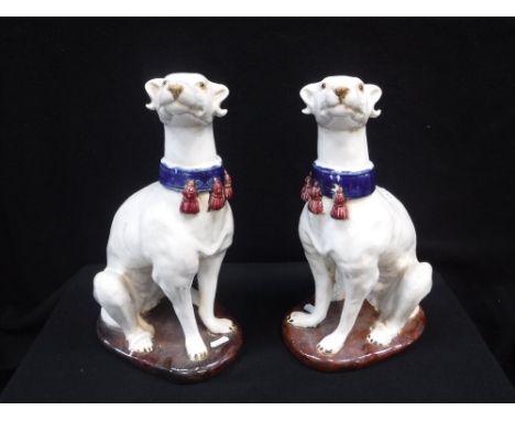 A PAIR OF GLAZED CERAMIC WHIPPETS each wearing a blue collar, 14" high