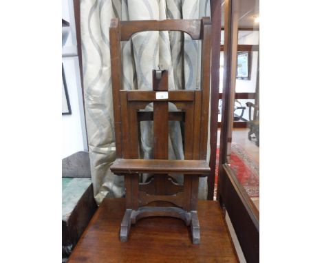 AN EARLY 20TH CENTURY WALNUT ADJUSTABLE EASEL of small proportions with brass fittings, 29" high (approx as adjustable)