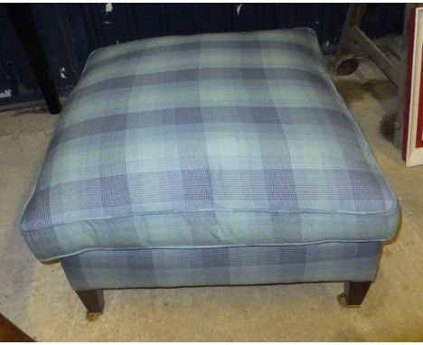 A modern blue check upholstered stool with cushion on square tapered legs to brass castors