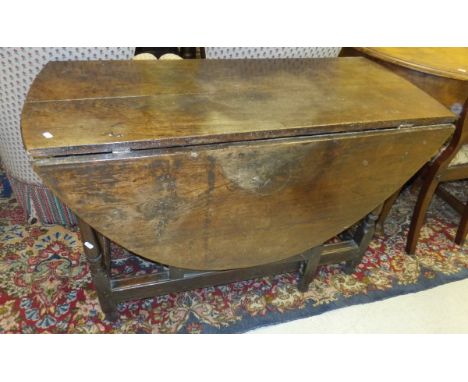 A 19th Century oak oval gate-leg table raised on turned and ringed legs to block feet