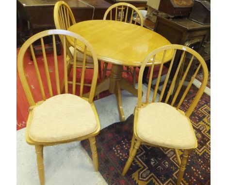 A modern stained beech pedestal kitchen table and four stick back chairs