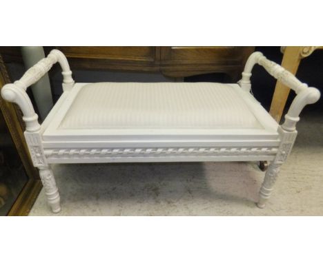 A modern cream painted window bench with lift up seat and cream upholstered top