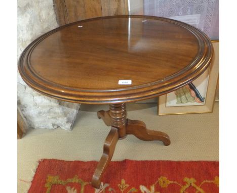 A 19th Century circular mahogany tea table, the snap top with moulded edge raised on bobbin turned column to tripod base