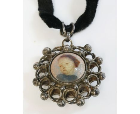 An Arts and Crafts silver enamel pendant, with a polychrome enamelled boss to the centre depicting the head of a young girl t