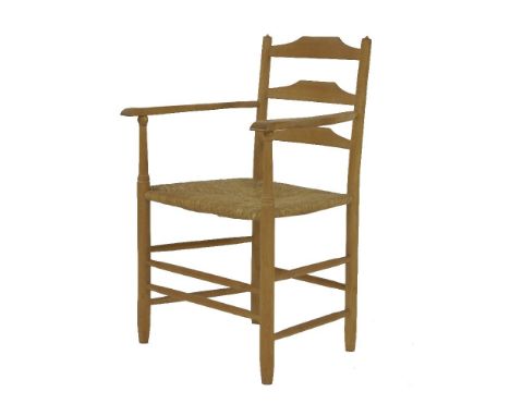 An ash ladder back armchair,  by Neville Neal with a rush seat, stamped to back leg