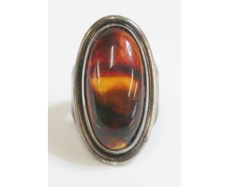 A sterling silver Danish modernist ring, by Hermann Siersb›l with an oval cabochon amber, rub set to the centre, with a round