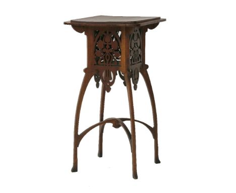 An Art Nouveau oak lamp table, the stepped top, over a pierced basket with stylised motifs, on shaped supports, united with a