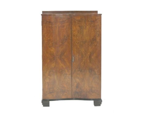 A walnut serpentine tallboy, opening to reveal a shelf and two slides, raised on an ebonised stand, 78cm wide 50cm deep 124cm