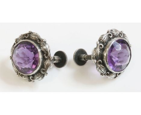 A pair of silver Arts and Crafts amethyst earrings, attributed to Bernard Instone, a circular mixed cut amethyst rub set to a