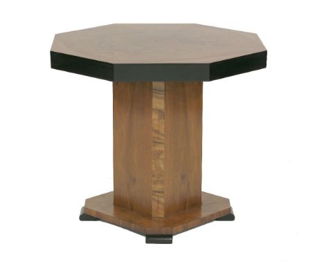 An Art Deco walnut and ebonised lamp table, with an octagonal top over a chamfered column, on a platform base, on block feet,