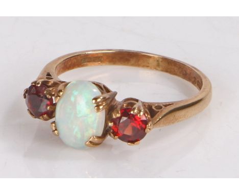 9 carat gold ring the pierced shoulders to the head set with a central opal and two garnets ring size L 