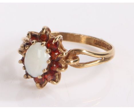 9 carat gold ring with tear drop pierced shoulders under an opal set in garnet surround.  ring size L 1/2