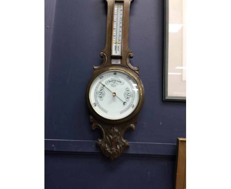 LATE VICTORIAN/EDWARDIAN CARVED OAK BAROMETER
with white enamel dial, 86cm long