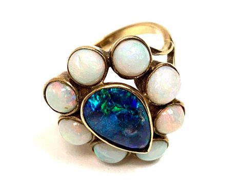 An opal cluster ring, stamped '9ct', the central opal doublet enclosed by eight round opals, finger size M, 5.3 g gross