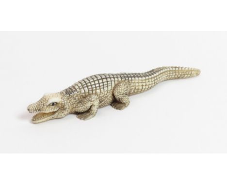 A Japanese ivory netsuke of a crocodile, signed to the base, 12cm long