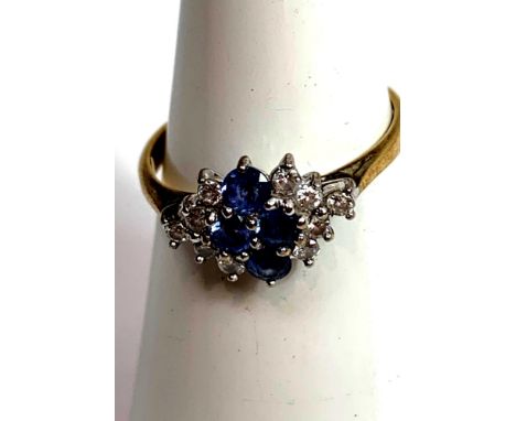 An 18 carat gold sapphire and diamond cluster ring, the four round cuts flanked either side by five small brilliant cuts, fin