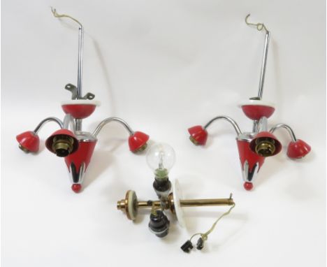 A pair of mid century ceiling light fittings with opaque glass shades, variously decorated in black, red, and gold, the fitti