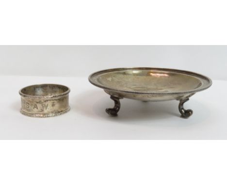 A circular shallow dish, by Mappin &amp; Webb, Birmingham 1909, hammered in the Arts and Crafts style, raised on three scroll