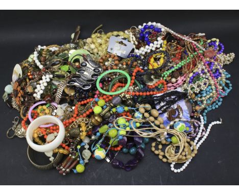 A large box of costume jewellery. Including beaded and pearl necklaces, bangles, brooches, etc