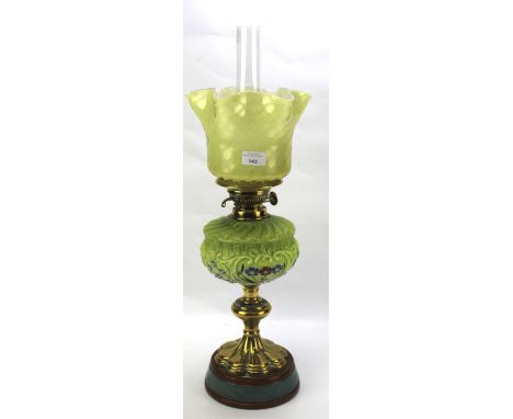 An early 20th century oil lamp. With vaseline glass style shade and coloured painted glass reservoir, on brass stand, H64cm  