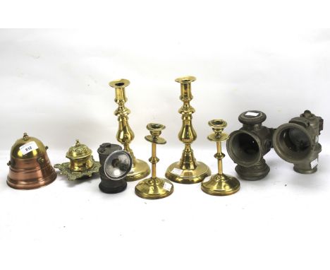 An assortment of metalware. Including two pairs of brass candlesticks, two lamps, an inkwell, etc