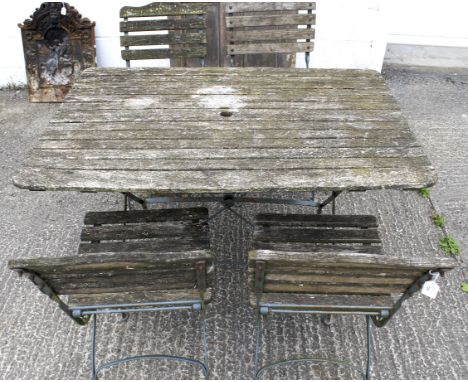 A vintage garden table and four chairs. The table of rectangular form, with plank top and cast metal supports, table L120cm x