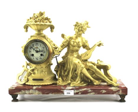 A early 20th century gilt cased mantel clock. The enamel dial with Arabic numerals and painted with flowers, placed in a mode